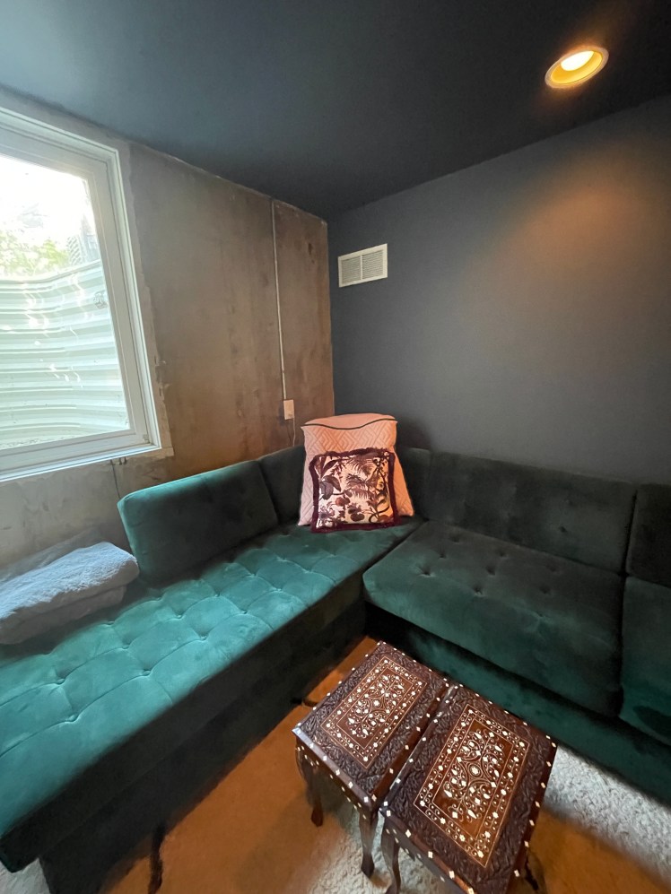 For A's basement office, we chose a deep, rich chocolatey grey that could holds its own beside that textured cement wall and the emerald sofas.